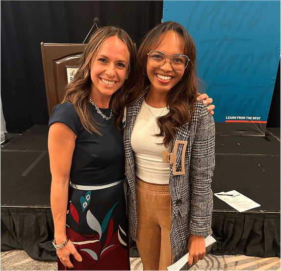 Amber Vilhauer smiling next to a books and business attendee